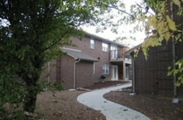 Brick apartment buildings with a paved path exterior at Denice.com in Columbia Student Accommodation