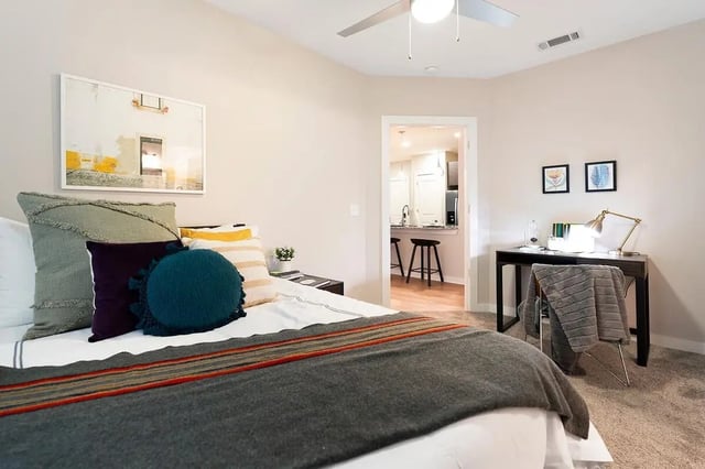Bed with pillows desk and kitchen view bedroom at The Indy in Marietta Student Accommodation