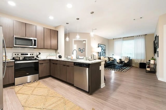 Modern kitchen with stainless steel appliances and open living room. at The Indy in Marietta Student Accommodation