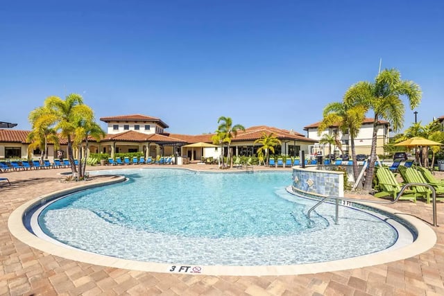 Resort style pool with lounge chairs and palm trees Exterior at The Reef Student Living in Fort Myers Student Accommodation