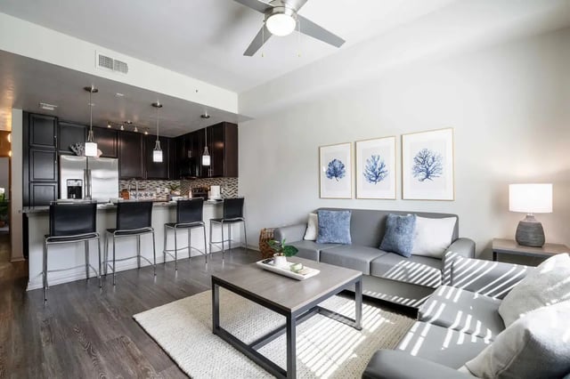 Sofa coffee table bar stools and kitchen living room at The Reef Student Living in Fort Myers Student Accommodation