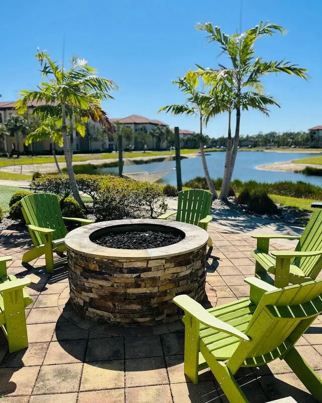 Fire pit palm trees and Adirondack chairs patio area at The Reef Student Living in Fort Myers Student Accommodation