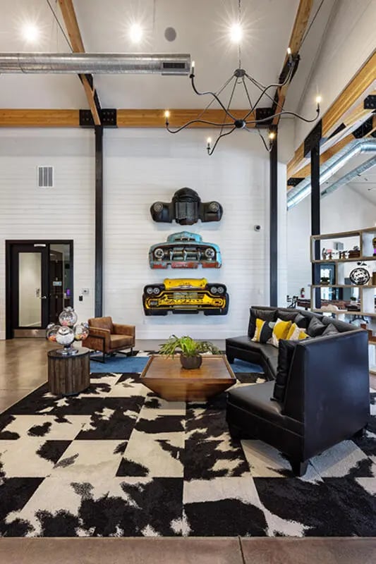 Living room with leather sofas and car art at University Trails Apartments in Ann Arbor Student Accommodation
