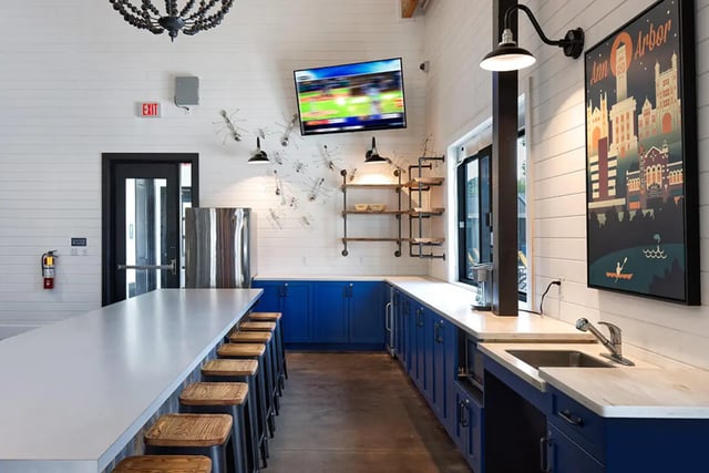 Island counter stools industrial shelves blue cabinets kitchen at University Trails Apartments in Ann Arbor Student Accommodation