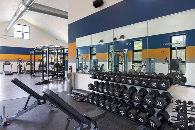 Gym equipment with weight benches and dumbbells gym area at University Trails Apartments in Ann Arbor Student Accommodation