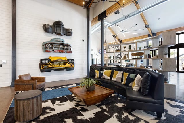 Car parts wall art black couch living room at University Trails Apartments in Ann Arbor Student Accommodation
