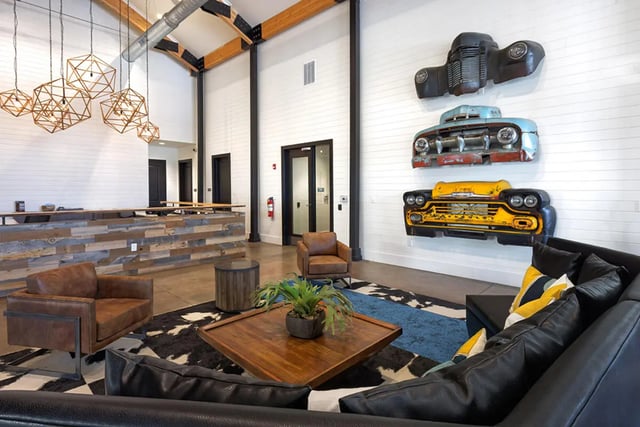 Lounge with leather sofas and car decor living room at University Trails Apartments in Ann Arbor Student Accommodation
