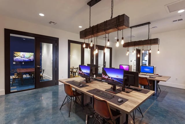 Computers on desks with chairs study area at University Trails Apartments in Ann Arbor Student Accommodation