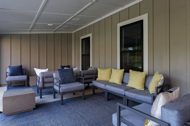 Gray outdoor seating with blue yellow pillows exterior at University Trails Apartments in Ann Arbor Student Accommodation