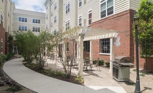 Grill tables chairs under pergola building exterior at University Edge Apartments in Akron Student Accommodation