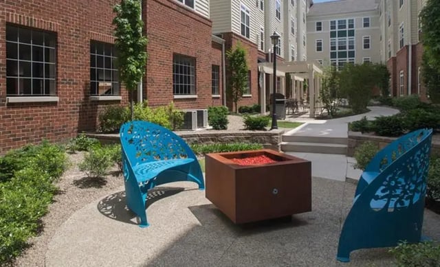 Blue benches with fire pit exterior at University Edge Apartments in Akron Student Accommodation