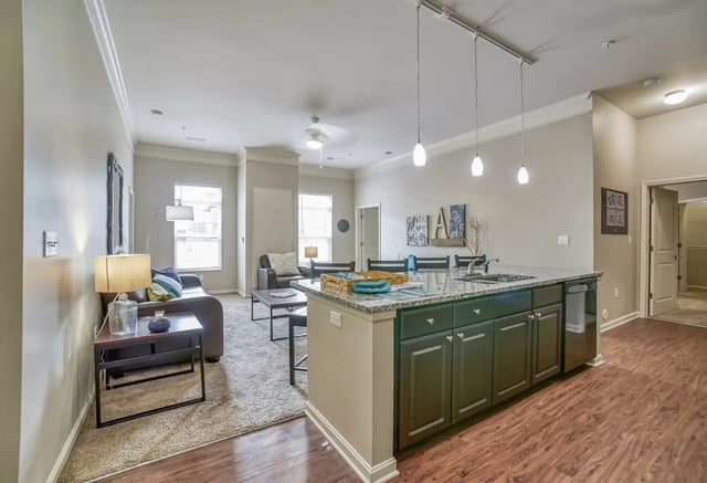Living room with sofa kitchen island and dining area at University Edge Apartments in Akron Student Accommodation