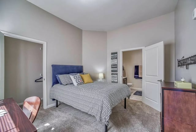 Bed with pillows desk chair closet bathroom view bedroom at University Edge Apartments in Akron Student Accommodation