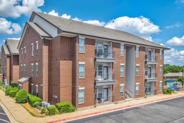 Brick apartment building with balconies exterior at The Rendezvous Apartments in Edmond Student Accommodation