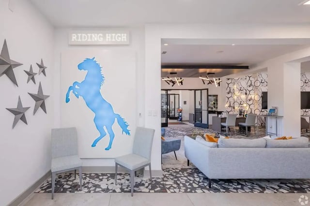 Blue horse art stars and chairs living room at The Rendezvous Apartments in Edmond Student Accommodation