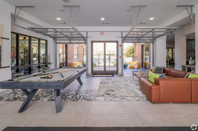 Pool table sofa gym equipment seating area living room at The Rendezvous Apartments in Edmond Student Accommodation