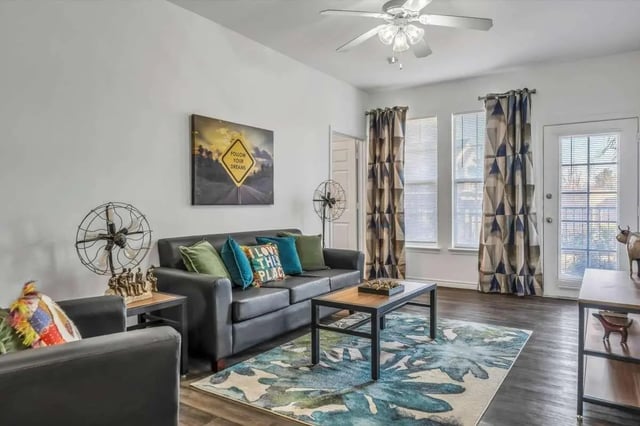 Black sofa with colorful pillows and coffee table living room at The Rendezvous Apartments in Edmond Student Accommodation