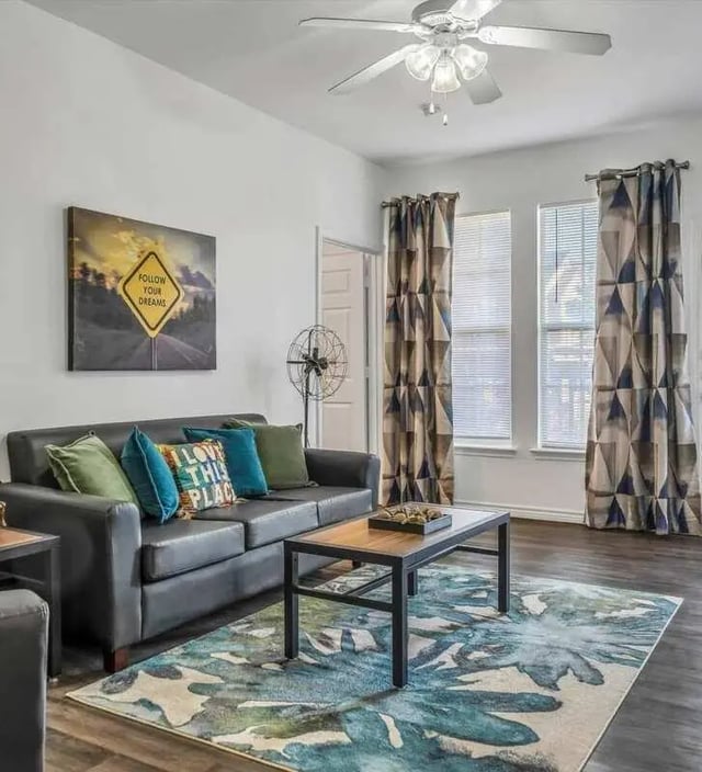 Black sofa with colorful pillows coffee table rug living room at The Rendezvous Apartments in Edmond Student Accommodation