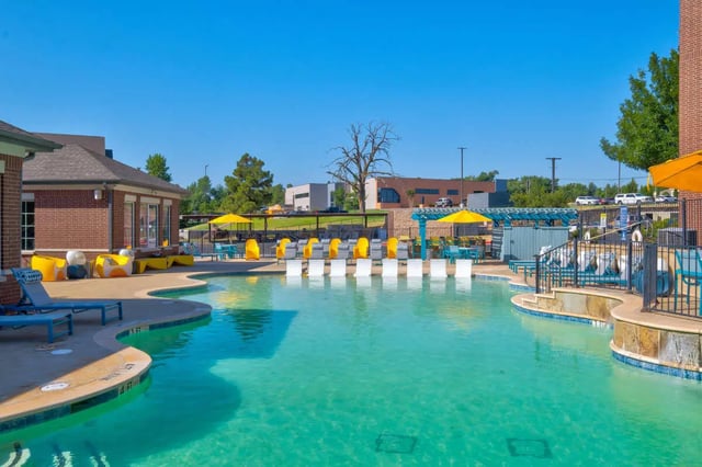 Pool with lounge chairs and umbrellas exterior at The Rendezvous Apartments in Edmond Student Accommodation