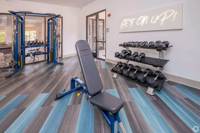Gym equipment weight bench dumbbell racks fitness room at The Rendezvous Apartments in Edmond Student Accommodation