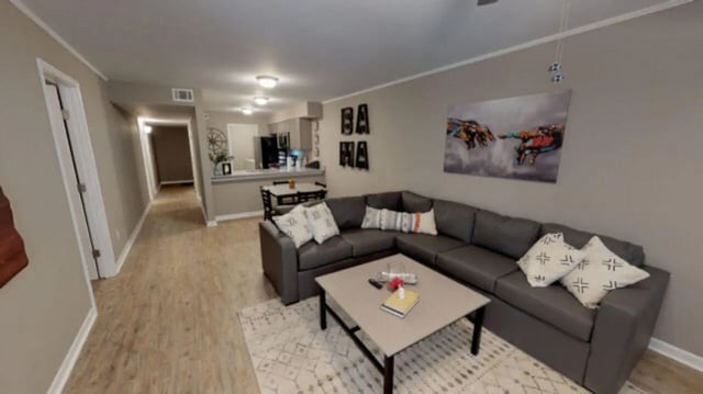 Grey sectional sofa coffee table rug living room at Hillside Commons in Tuscaloosa Student Accommodation