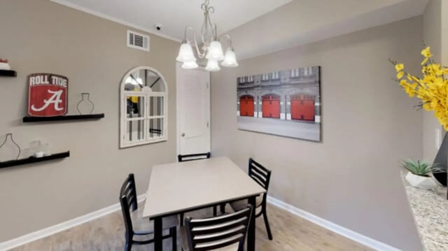 Table with chairs and wall decor dining area at Hillside Commons in Tuscaloosa Student Accommodation