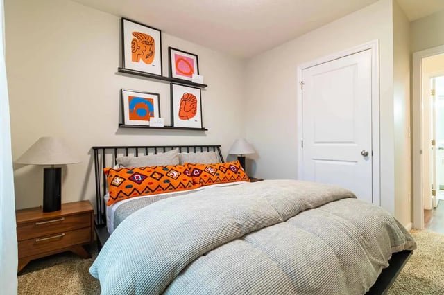 Bed with orange pillows and artwork Bedroom at PPG East Village in Columbus Student Accommodation