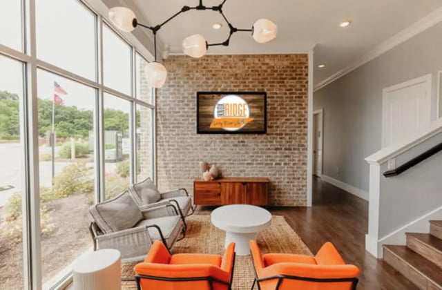 Sofa orange chairs white table modern lounge Living room at Knox Ridge in Knoxville Student Accommodation