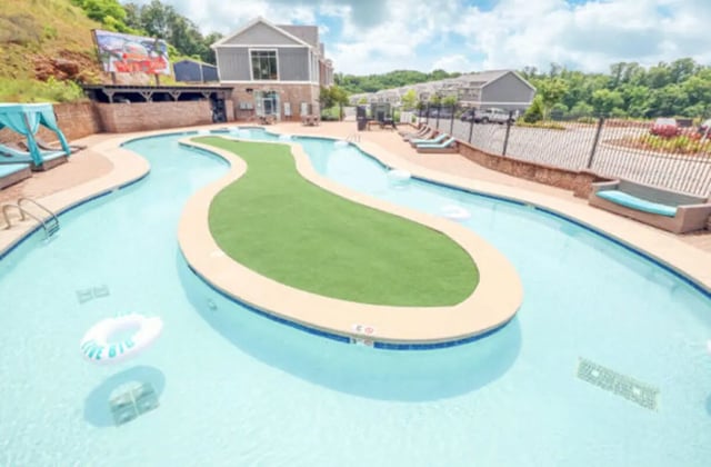 Pool with island lounge chairs and building exterior at Knox Ridge in Knoxville Student Accommodation