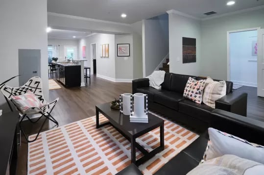Black sofa coffee table patterned rug living room at Knox Ridge in Knoxville Student Accommodation