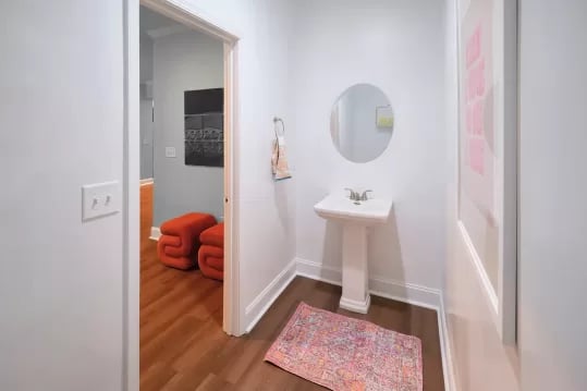 Pedestal sink mirror rug and two orange ottomans bathroom at Knox Ridge in Knoxville Student Accommodation