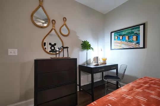 Dark dresser, desk, chair, painting, mirrors bedroom at Knox Ridge in Knoxville Student Accommodation