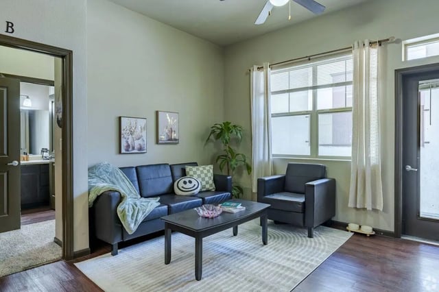 Black sofa armchair coffee table and rug living room at The Republic in Reno Student Accommodation