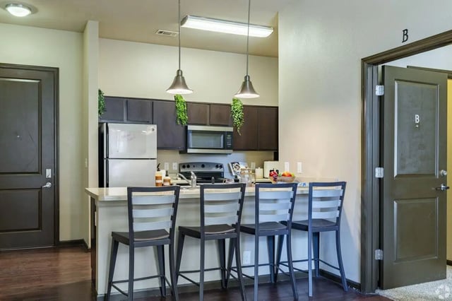 Kitchen island with chairs and appliances kitchen at The Republic in Reno Student Accommodation