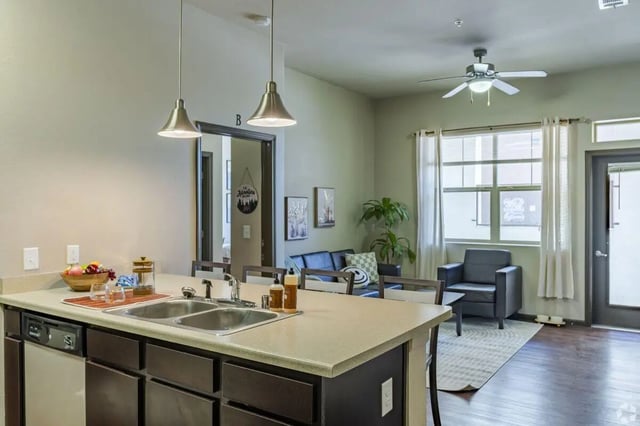 Kitchen island sink and living room seating living room at The Republic in Reno Student Accommodation