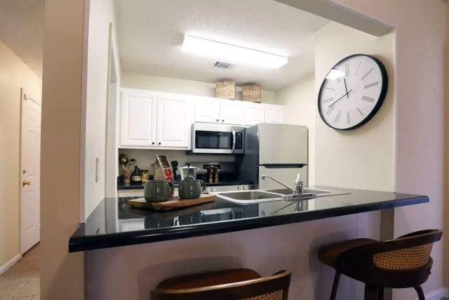 Bar counter coffee cups microwave refrigerator kitchen at Market 100 in Statesboro Student Accommodation
