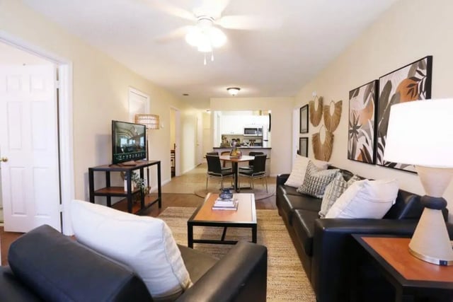 Black couches tv coffee table dining set living room at Market 100 in Statesboro Student Accommodation
