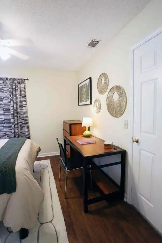 Bed desk chair rug and decorative wall art bedroom at Market 100 in Statesboro Student Accommodation