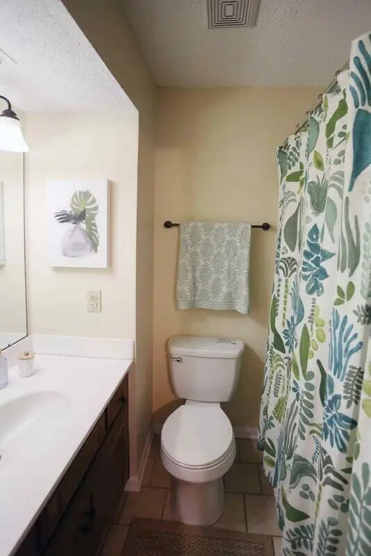 Toilet sink vanity and floral shower curtain bathroom at Market 100 in Statesboro Student Accommodation