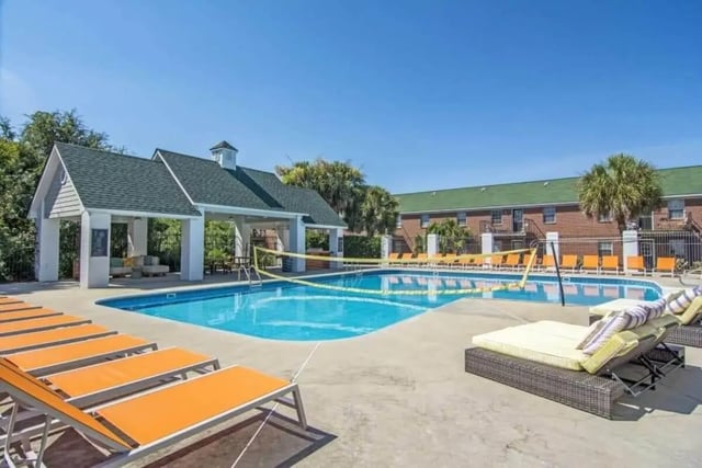 Pool volleyball court lounge chairs and covered seating area exterior at Market 100 in Statesboro Student Accommodation