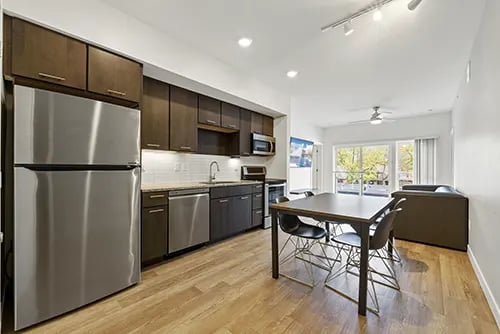 Stainless steel refrigerator cabinets dining table and chairs living room at The View on Pavey Square in Columbus Student Accommodation
