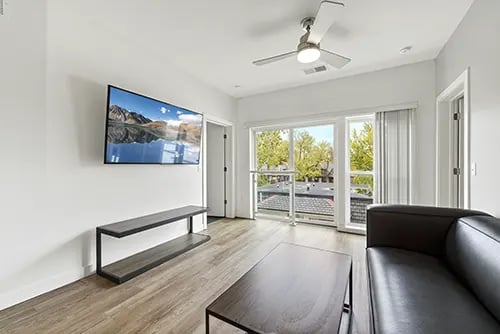 Wall mounted TV dark sofa and coffee table living room at The View on Pavey Square in Columbus Student Accommodation