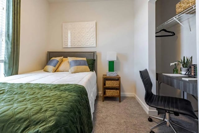 Bed with green blanket desk chair and closet bedroom at Hoffler Place in Charleston Student Accommodation