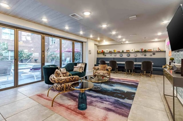 Green sofa tiger chairs glass tables lounge area at Hoffler Place in Charleston Student Accommodation
