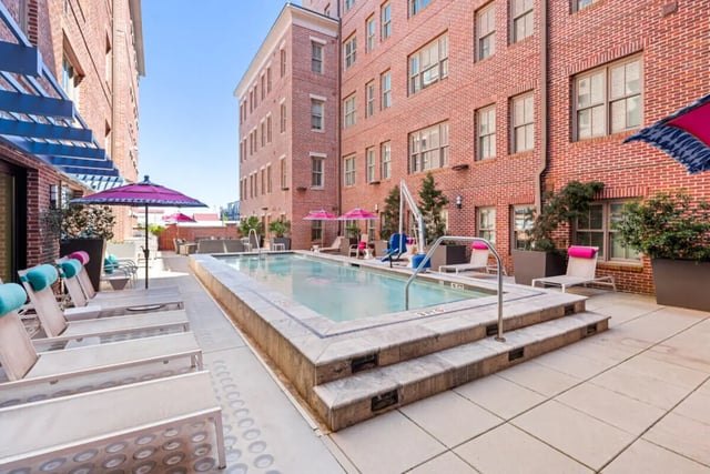 Pool lounge chairs umbrellas outdoor seating pool area exterior at Hoffler Place in Charleston Student Accommodation