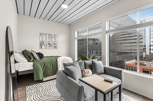 Bed sofa mirror artwork and large windows living room at HERE Pittsburgh in Pittsburgh Student Accommodation