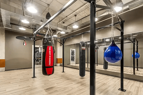 Boxing bags in gym with mirrors gym at HERE Pittsburgh in Pittsburgh Student Accommodation