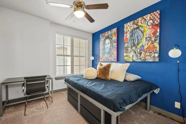Bed desk artwork and ceiling fan bedroom at Holleman Crossing in College Station Student Accommodation
