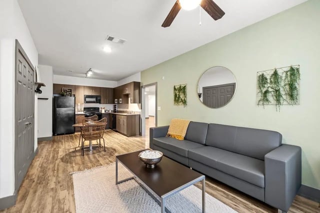 Modern grey sofa coffee table kitchen living room at Holleman Crossing in College Station Student Accommodation