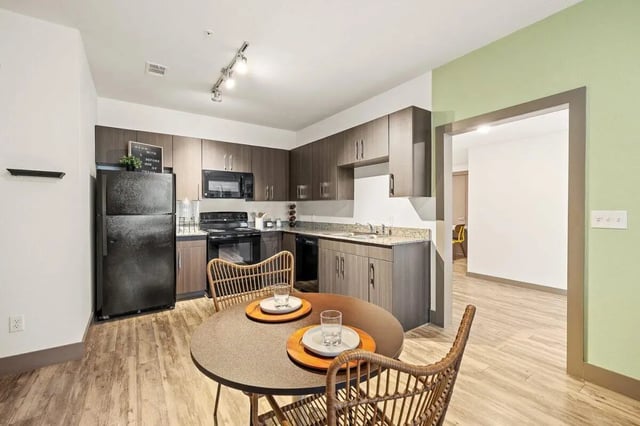 Kitchen with refrigerator table chairs and cabinets kitchen at Holleman Crossing in College Station Student Accommodation